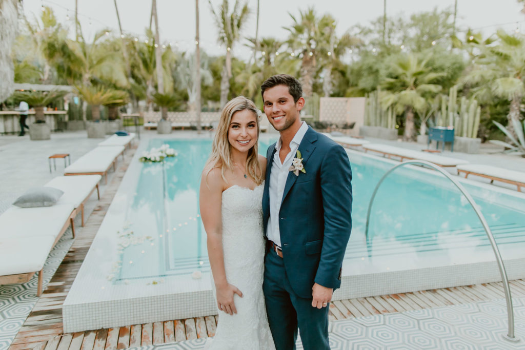 young married couple in front of pool after getting married in Cabo
